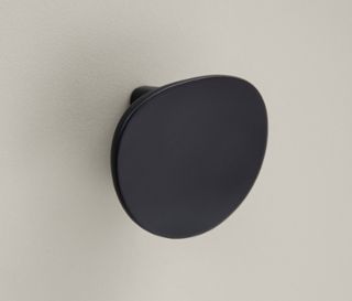 Detailaufnahme eines cremebeige Highboards »Edda« mit einer Tür, einer Schublade und einem runden, dunkelgrauen Griff.
