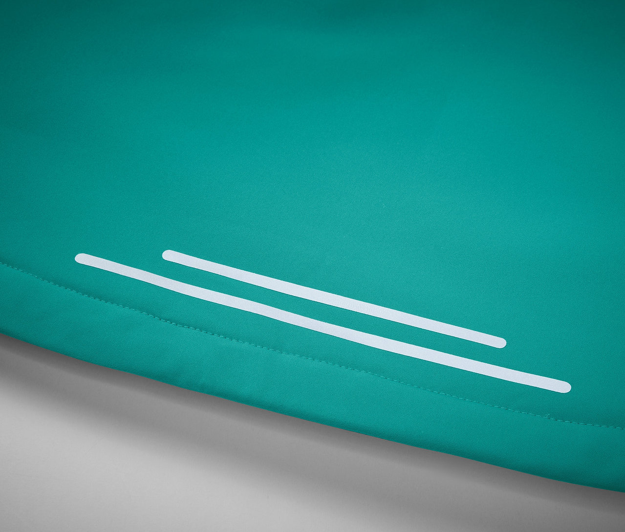 Detailaufnahme eines türkisfarbenen Stoffes mit zwei weißen Reflexstreifen.