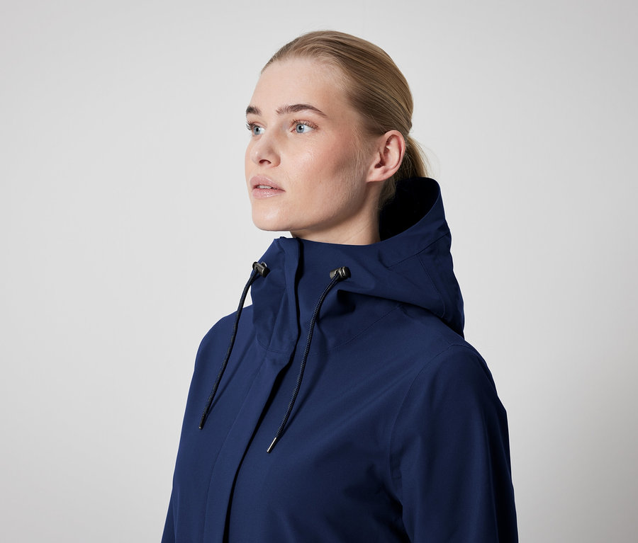 Eine Frau trägt eine dunkelblaue Jacke mit Kapuze.