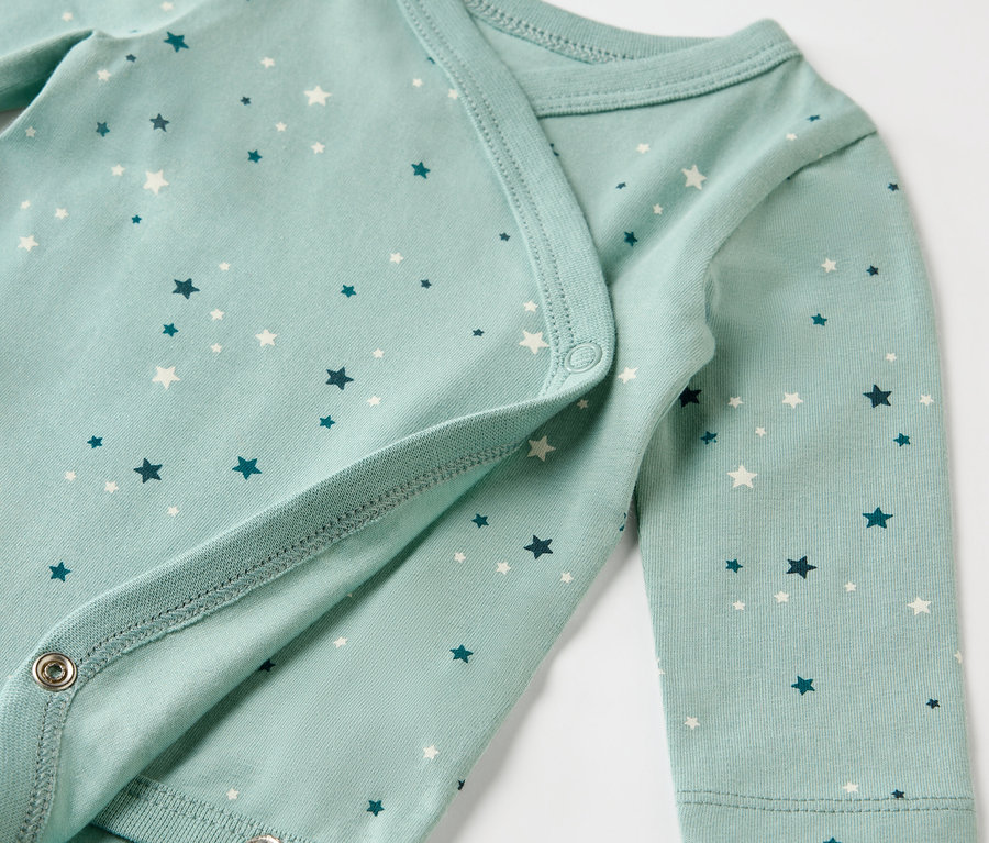 Detailaufnahme eines hellblauen Babybodys mit Sternenmuster.