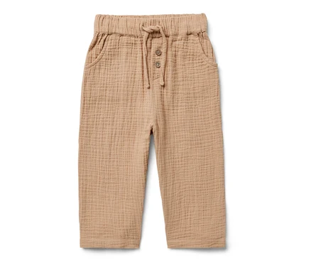 Eine hellbraune Kinder-Musselin-Hose mit Knöpfen und Kordelzug in der Taille.