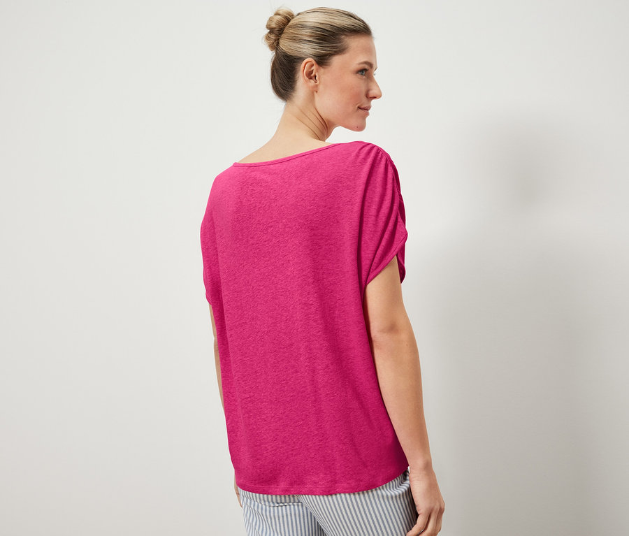 Frau trägt ein Shirt aus Leinenmix und eine gestreifte Hose.