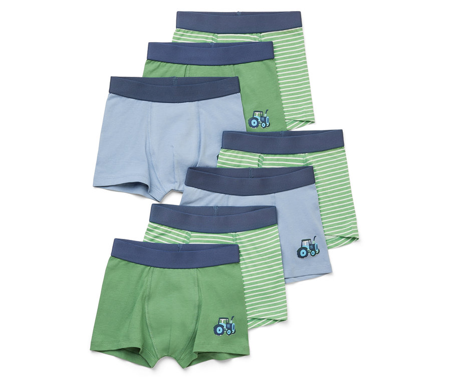 Sechs Kinderboxershorts in Grün- und Blautönen, einige mit Traktormotiven und Streifen.