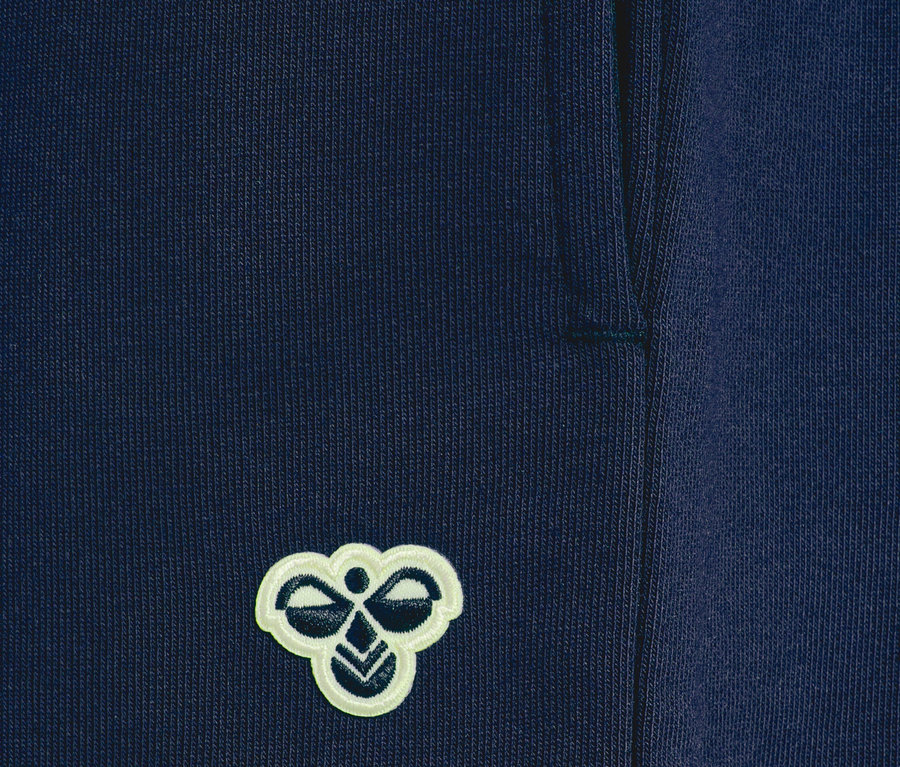 Detailaufnahme einer marineblauen Trainingshose mit dem Hummel-Logo.