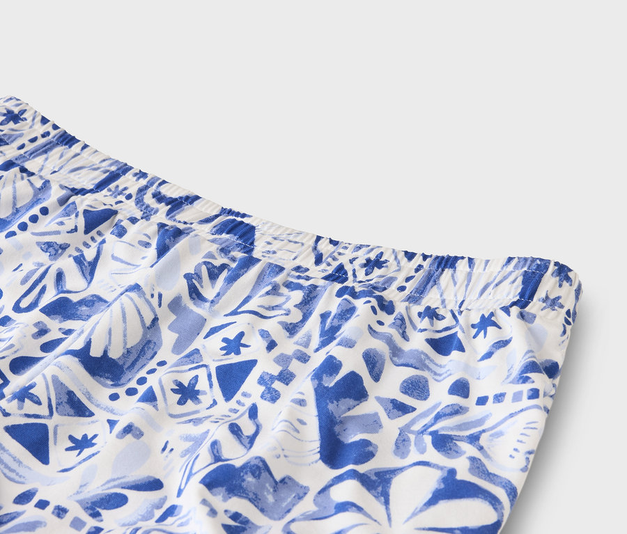 Nahaufnahme vom Bund einer weißen Hose mit blauem Muster.