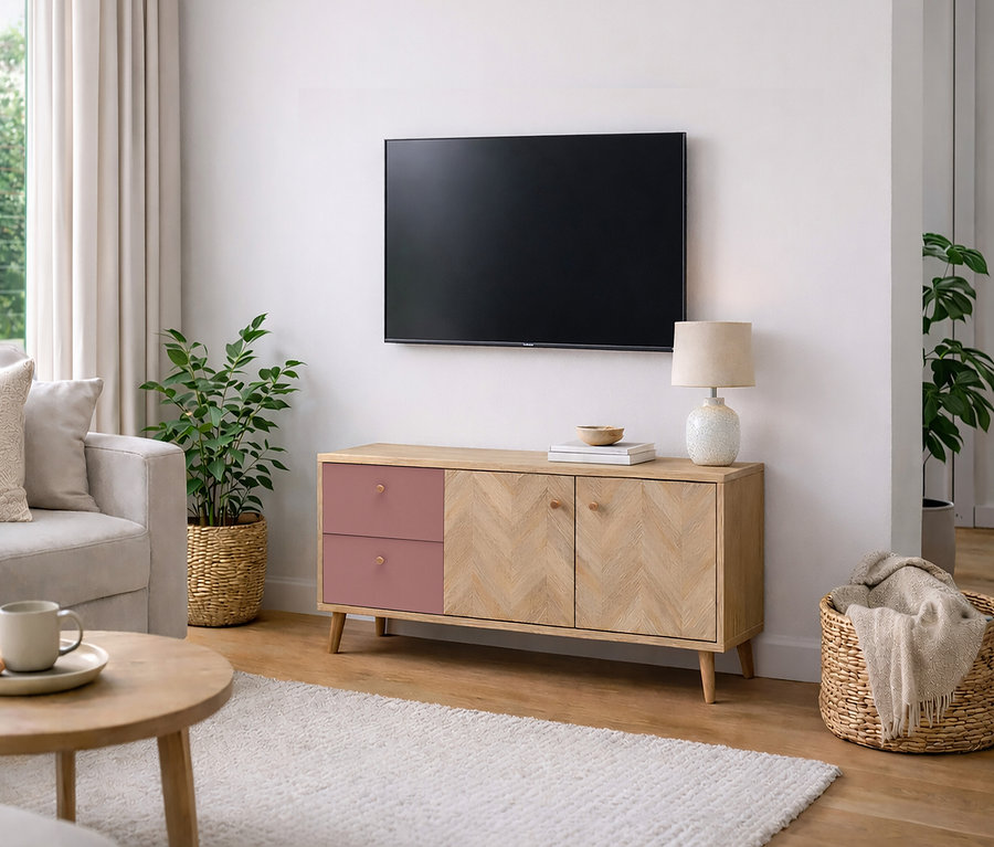 Wohnzimmer mit Fernseher an der Wand über einem Holzschrank mit rosa Schubladen, Lampe, Pflanze und Korb.