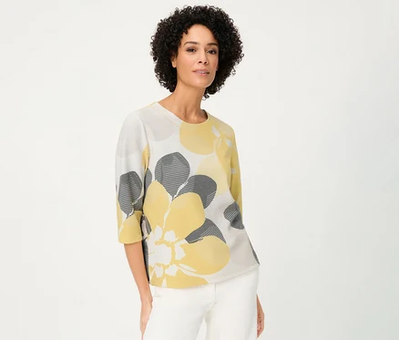 Frau trägt Olsen Sweatshirt »Ottoman« mit gelben und grauen Blumen vor einem weißen Hintergrund.
