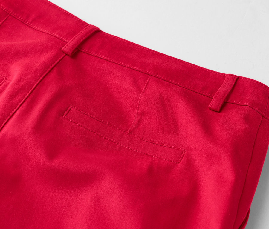 Detailansicht der Rückseite einer roten Hose mit Gesäßtasche und Gürtelschlaufen.