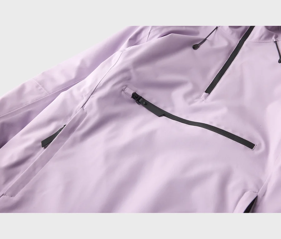 Nahaufnahme einer lila Jacke mit schwarzen Reißverschlüssen und Kordelzügen. Ein horizontaler schwarzer Reißverschluss ist unten links, ein diagonaler oben rechts.