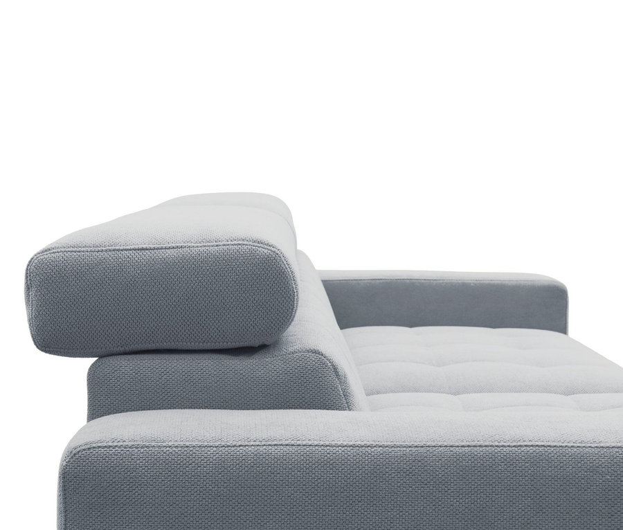 Nahaufnahme eines hellgrauen Sofas mit strukturiertem Stoff, verstellbarer Kopfstütze und getufteten Sitzkissen.