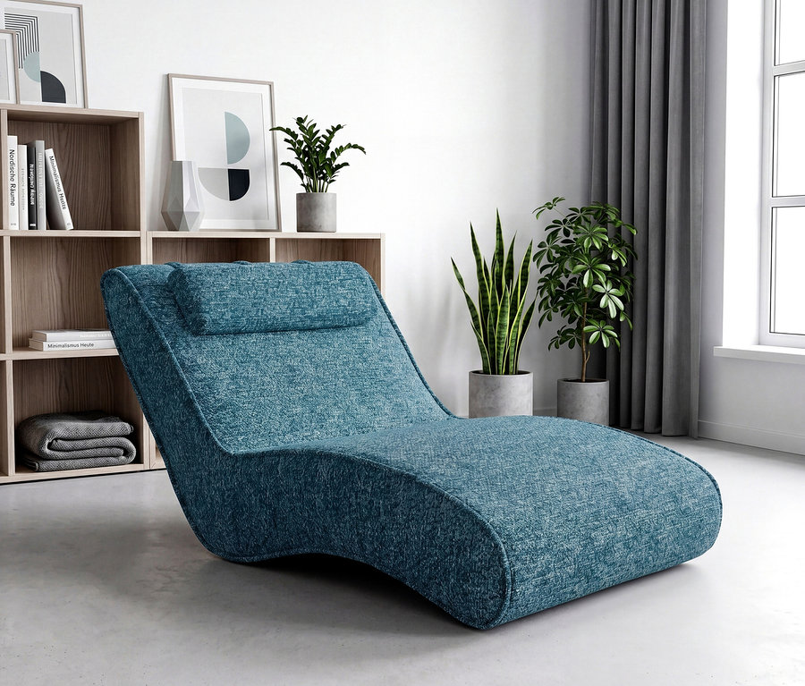 Ein modernes Wohnzimmer zeigt eine blaue, strukturierte Chaiselongue im Vordergrund. Dahinter steht ein helles Holzregal mit Büchern und abstrakten Kunstdrucken, umgeben von Topfpflanzen. Rechts befindet sich ein großes Fenster mit grauen Vorhängen.