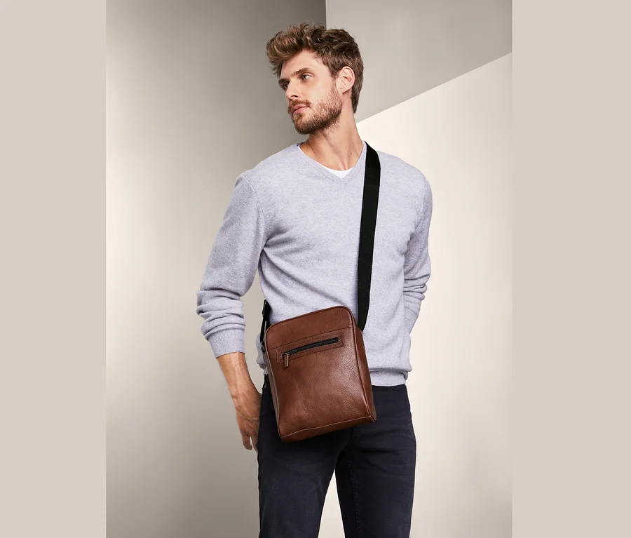 Mann posiert mit Leder-Crossbag.