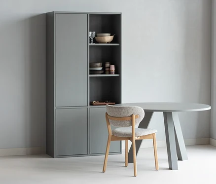 Grauer WOOOD Esstisch »Rhonda«, ca. 129 cm, mit einem Stuhl und einem grauen Schrank mit Geschirr.