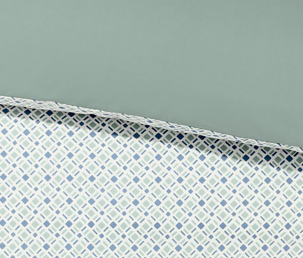 Nahaufnahme von Perkal-Wendebettwäsche mit Rautenmuster in Blau und Grün.