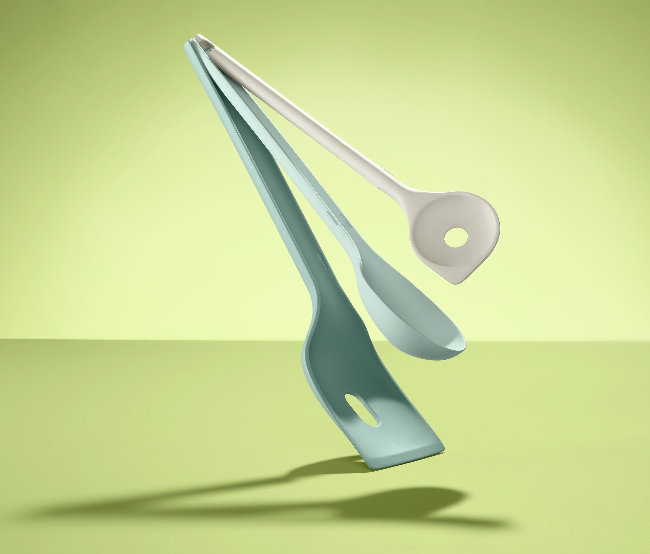 Schwebende 3 Küchenhelfer vor grünem Hintergrund.