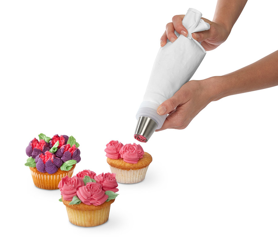 Eine Frau verziert einen Cupcake mit einem Spritztüllen-Set.