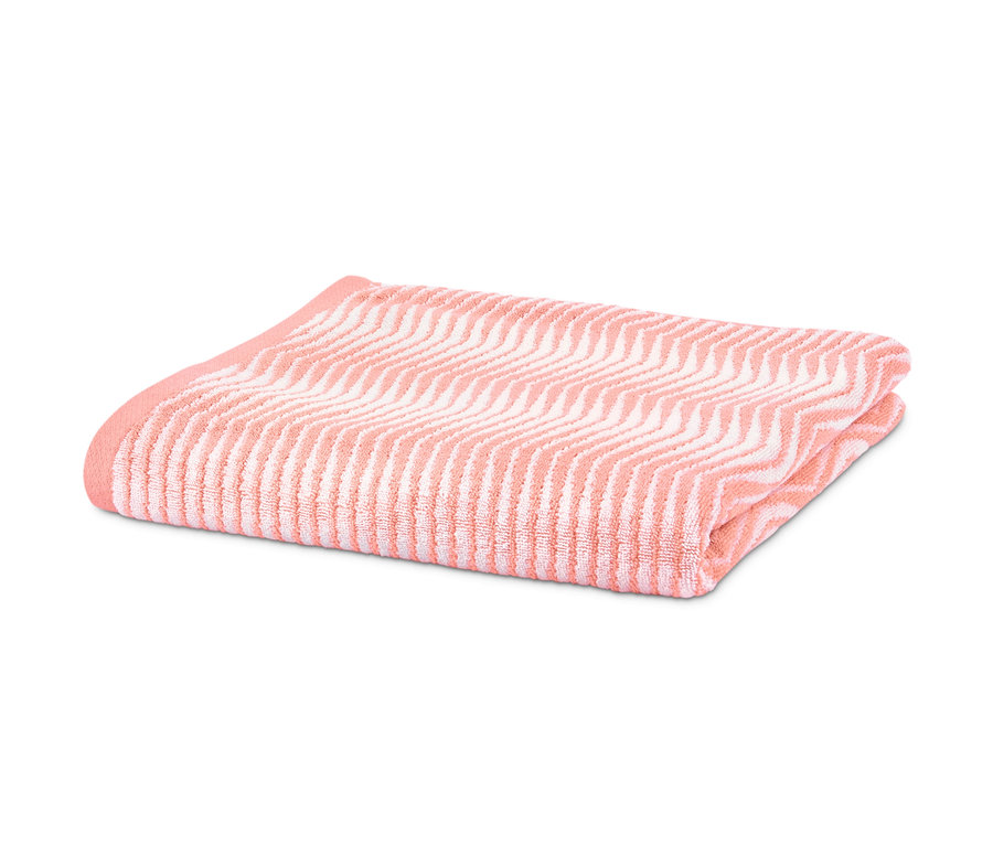 Zusammengelegtes Jacquard-Badetuch in Apricotfarben.