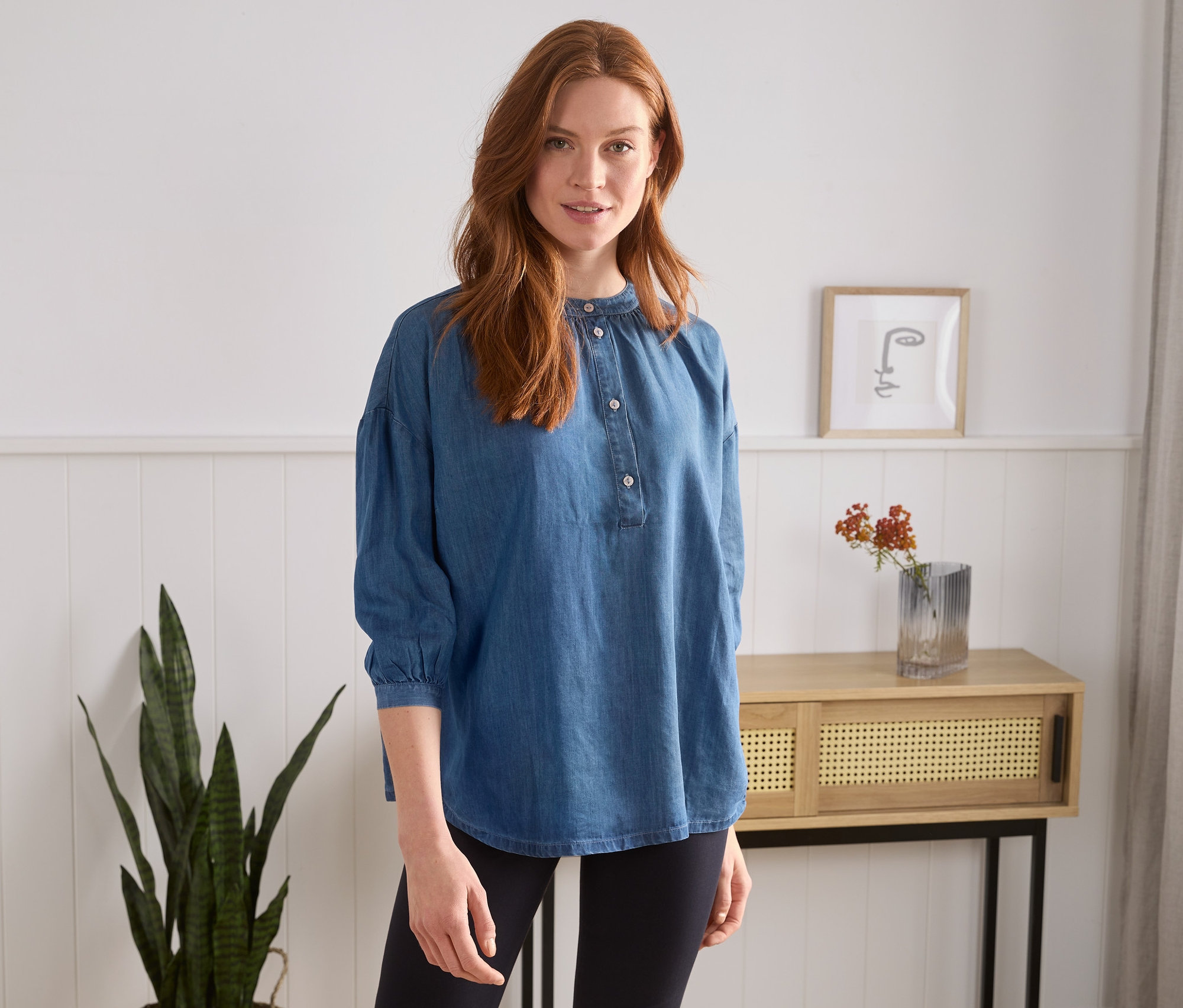 Eine Frau trägt eine Bluse in Denimoptik.