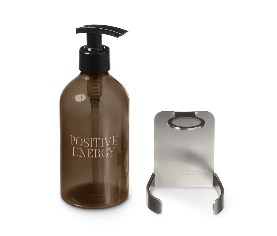 Braune Flasche mit Spender und dem Schriftzug Positive Energy neben Halter mit Seifenspender.