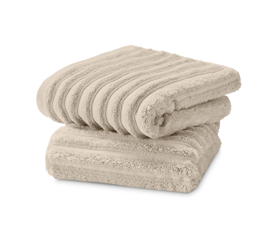 Zwei beige Premium-Handtücher mit Wellenstruktur im Set liegen gestapelt.