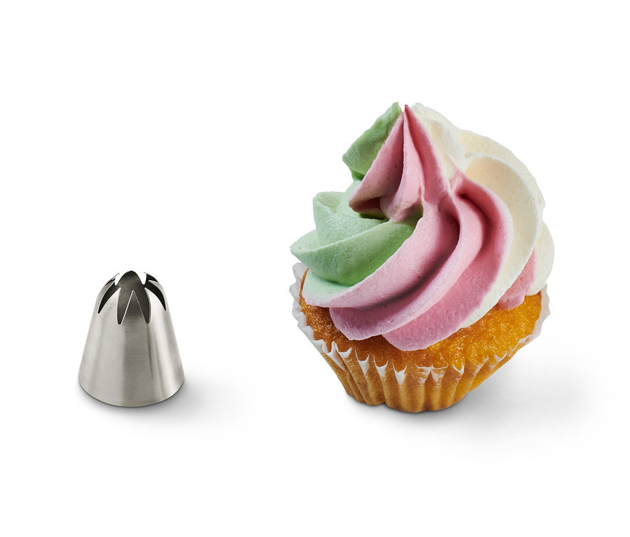 Neben einem verzierten Muffin befindet sich ein Multiadapter-Spritztüllen-Set.