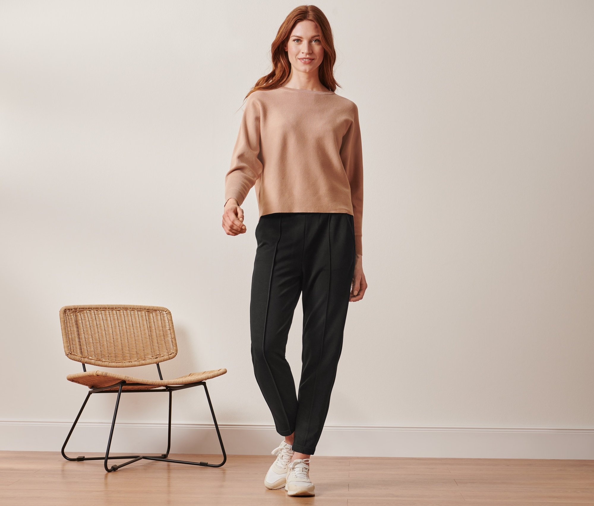 Frau steht und trägt eine schwarze Joggpants mit Biese.