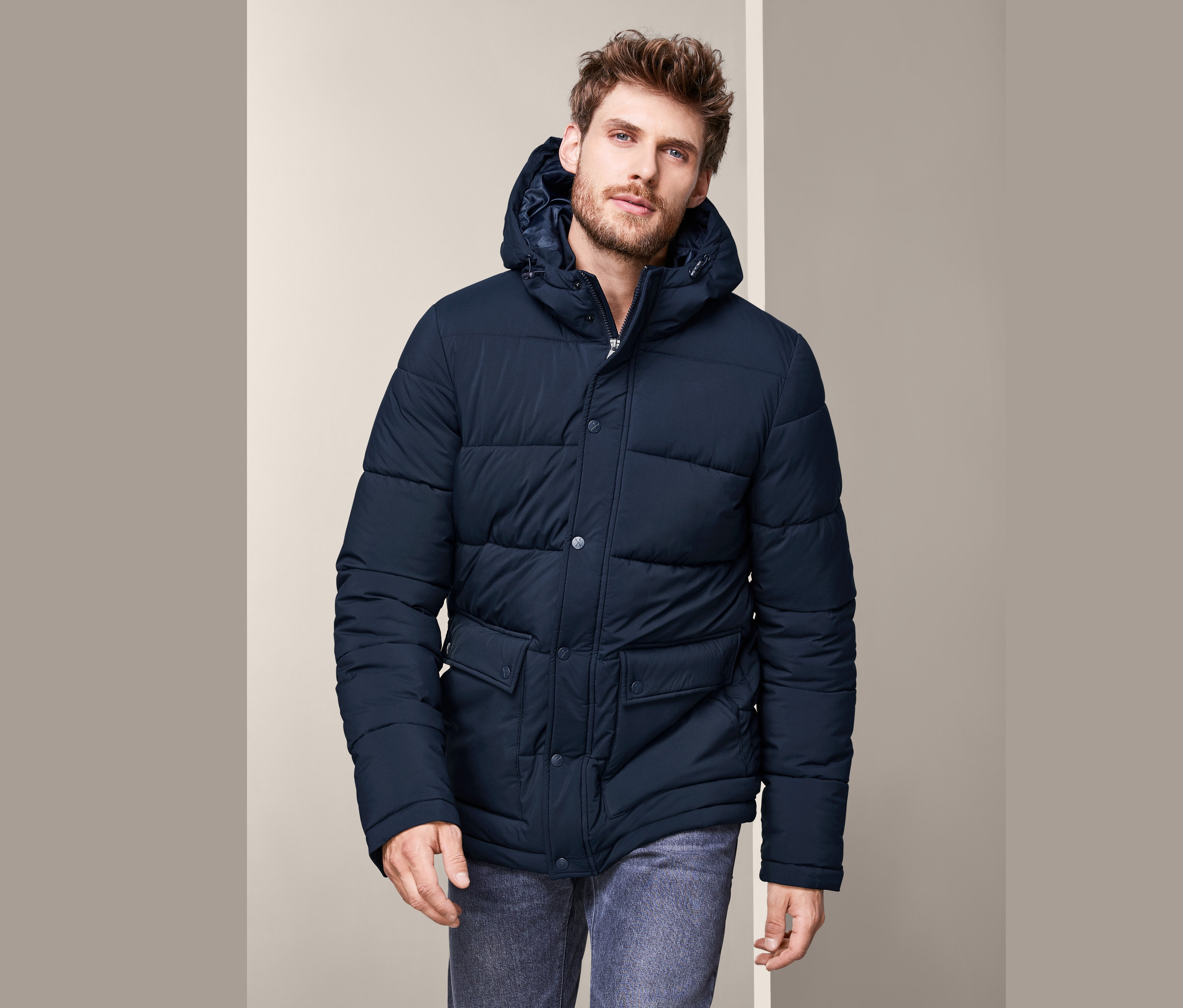 Mann trägt eine Thermo-Steppjacke und Jeans.