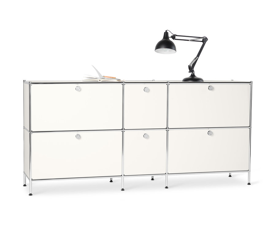 Weißes Sideboard Metall »CN3« groß mit 6 Klappenfächern. Auf der Oberseite liegen ein offenes Notizbuch und eine schwarze Lampe.