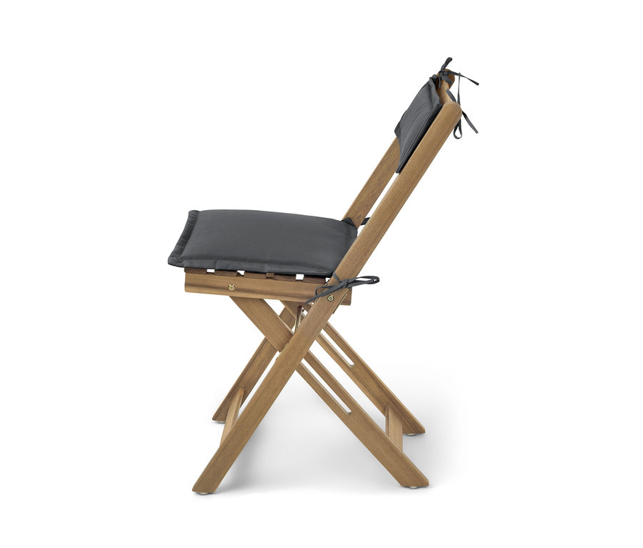 Detailansicht eines zusammenklappbaren Holzstuhls mit grauen Kissen auf Sitz und Rückenlehne.