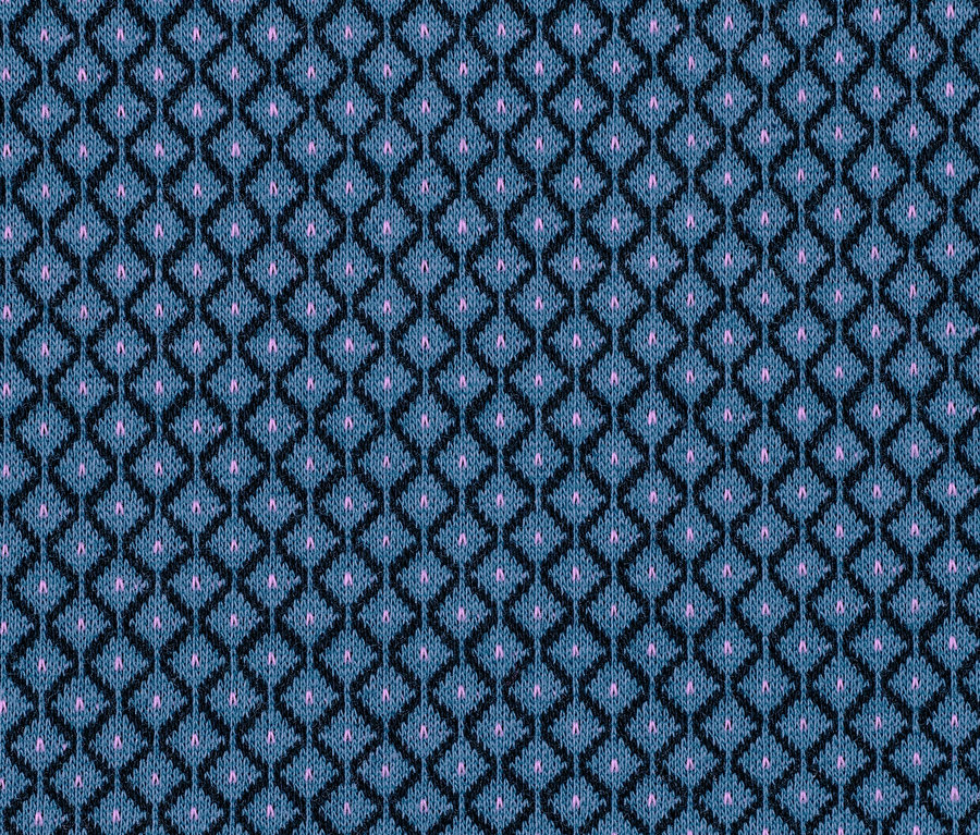 Nahaufnahme eines blauen Stretch-Dirndls mit schwarzem geometrischem Muster und rosa Punkten.