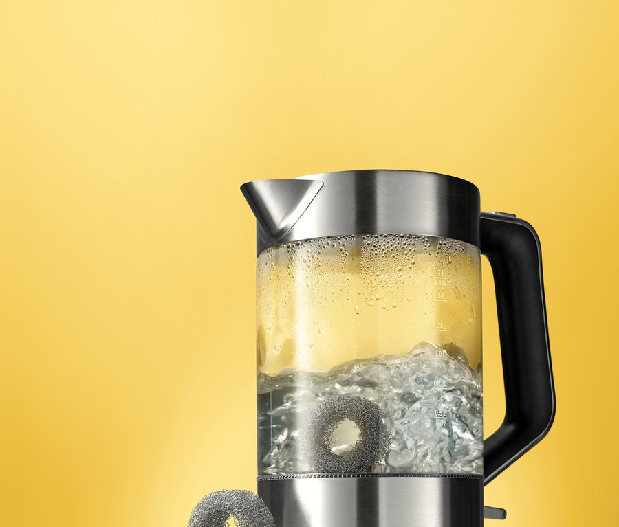 Glaskocher mit kochendem Wasser und zwei Kalkfängern.