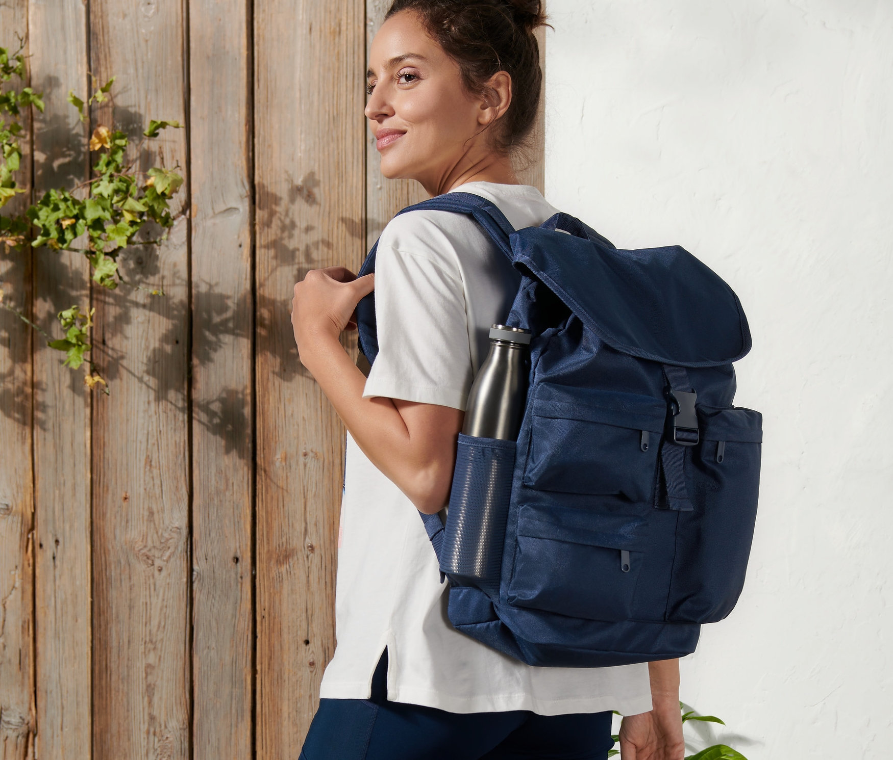 Frau mit Outdoor-Rucksack und Wasserflasche.