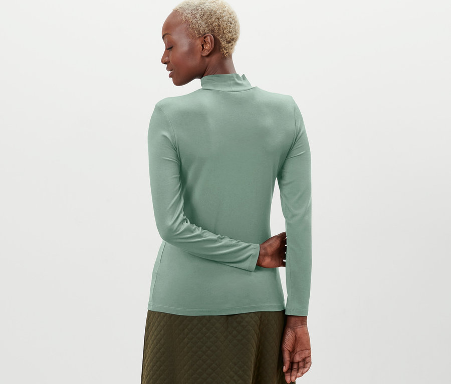 Frau von hinten trägt ein grünes Langarmshirt.