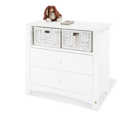 Weisse Kommode mit zwei Schubladen und zwei geflochtenen Körben obenauf. Auf der Kommode liegen ein Plüschhase und Babyschuhe.