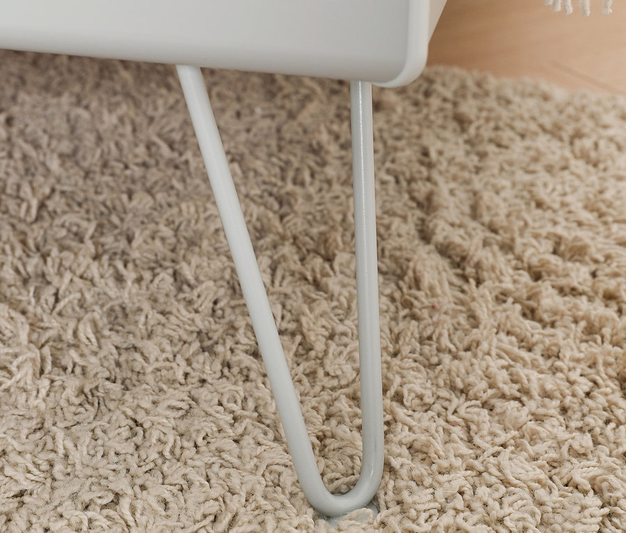 Detailaufnahme eines seidengrauen rauch Bettes »Homey« (ca. 180 x 200 cm) mit Metallfüßen auf einem beigen Teppich.