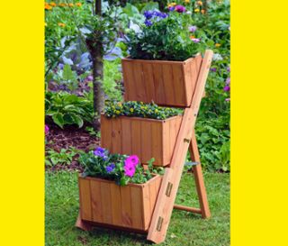 Braune Pflanztreppe mit 3 Pflanzkästen und Blumen im Garten.