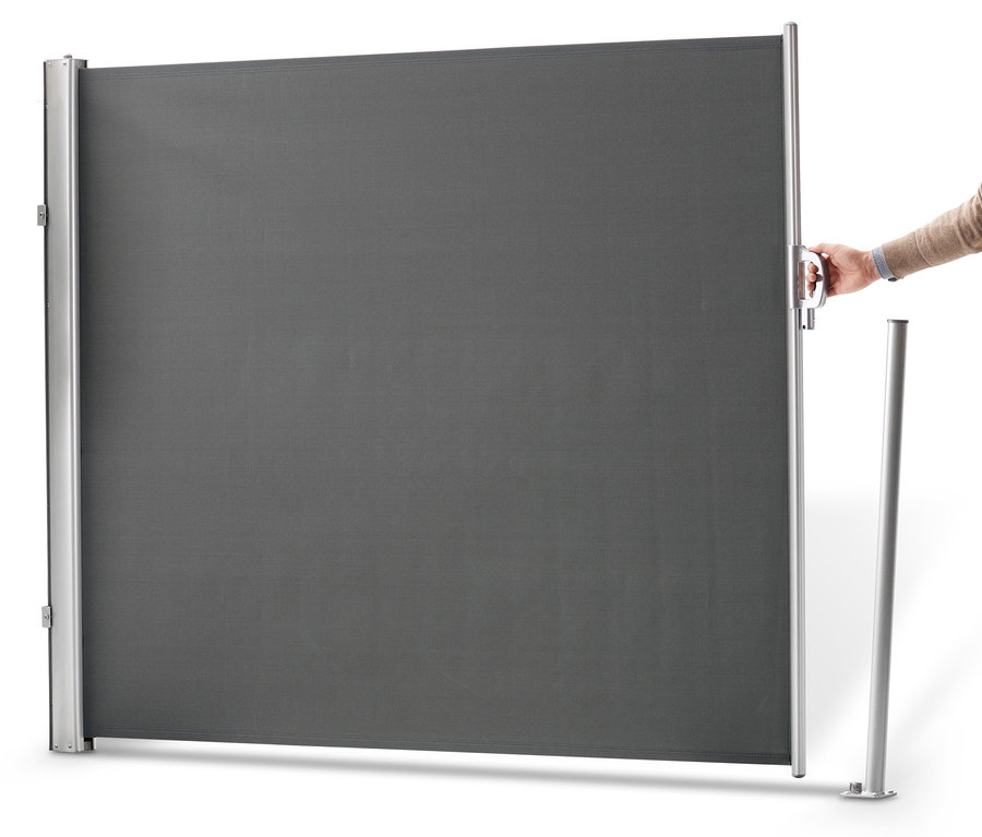 Eine Hand zieht eine graue Leco Seitenmarkise, 180 x 300 cm, heraus.