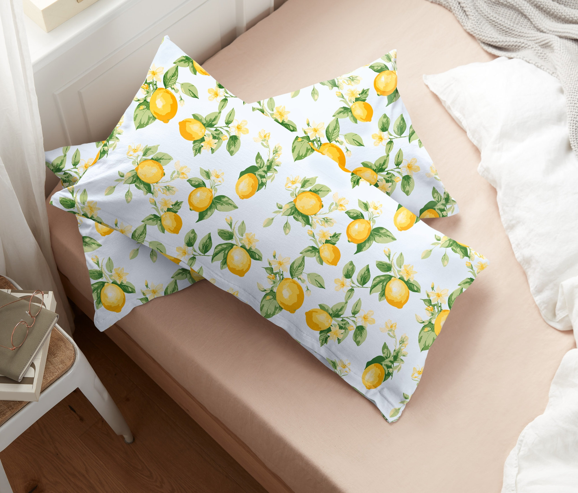 Zwei Jersey-Kopfkissenbezüge mit Zitronenmuster liegen auf einem Bett.