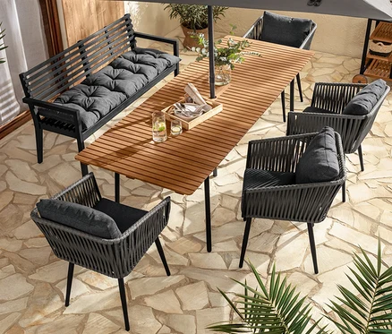 Eine Aussensitzgruppe mit Ausziehtisch »Elin«, Gartenbank mit Armlehne, Dining-Sesseln mit Textilgeflecht und Gartenbank-Auflage.