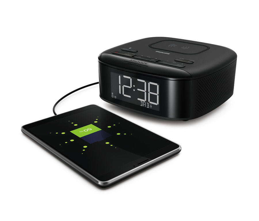 Ein schwarzer Philips DAB-Radiowecker »TAR7705« und ein aufladendes Tablet.