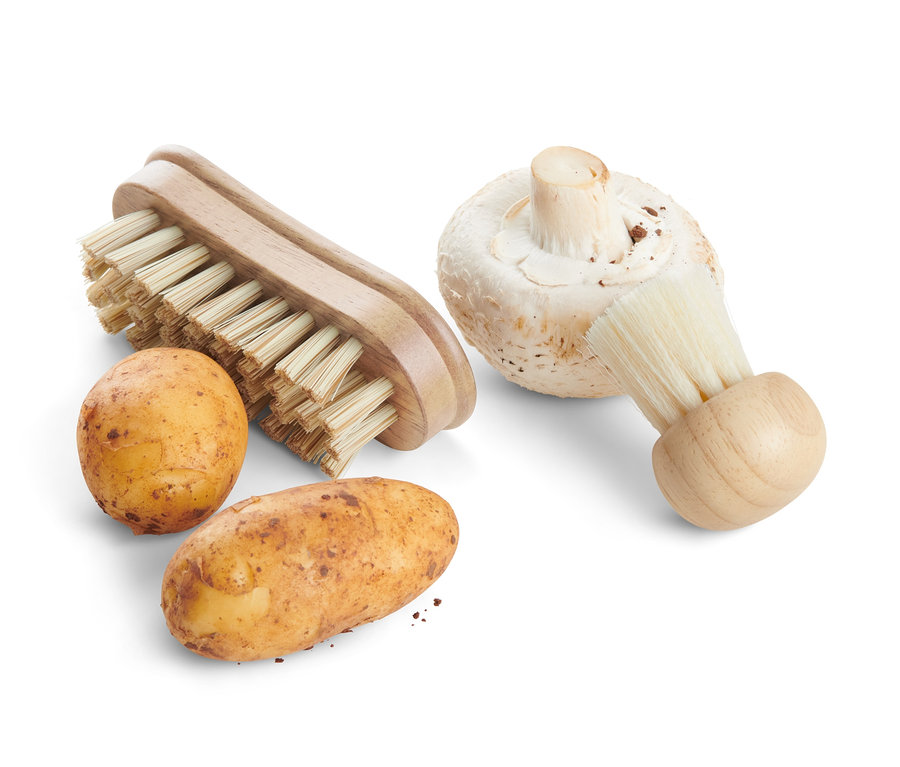 Zwei Kartoffeln und ein Champignon neben zwei Gemüsebürsten.