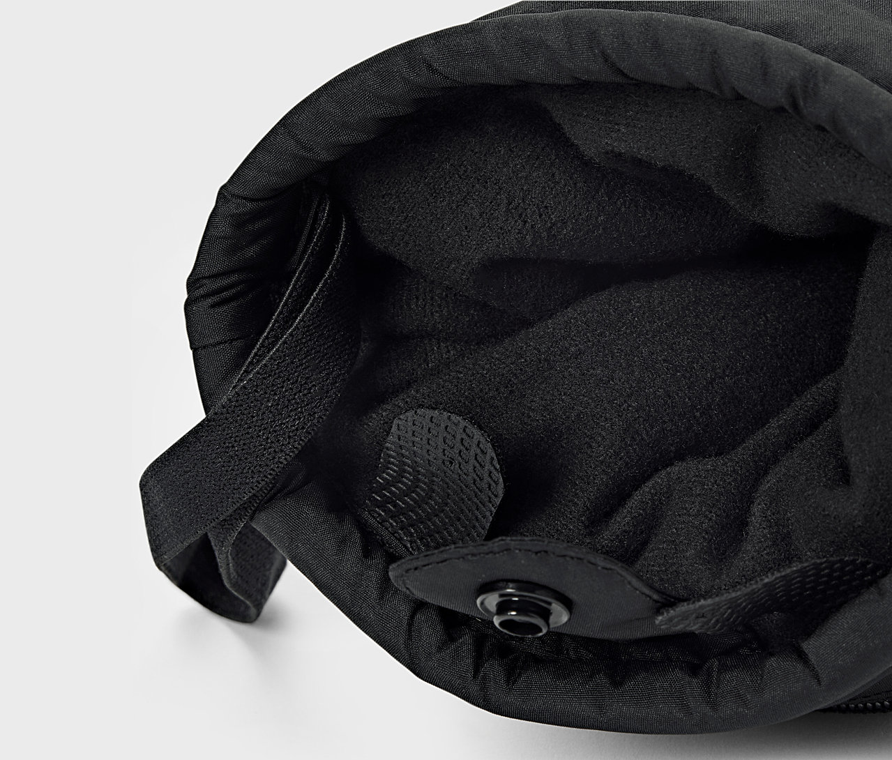 Detailaufnahme von schwarzem Stoff mit Innenfutter und Kordelzug.