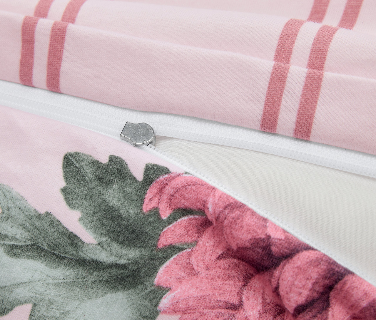 Detail einer Winterjersey-Bettwäsche in Normalgröße mit Blumenmuster, Streifen und silbernem Reißverschluss.