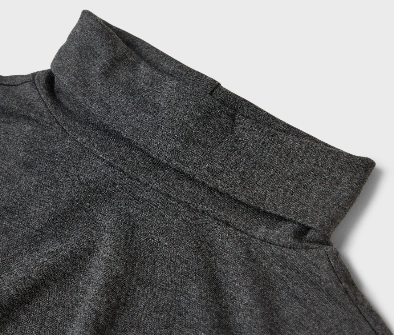 Detailaufnahme eines grauen Rollkragenpullovers.