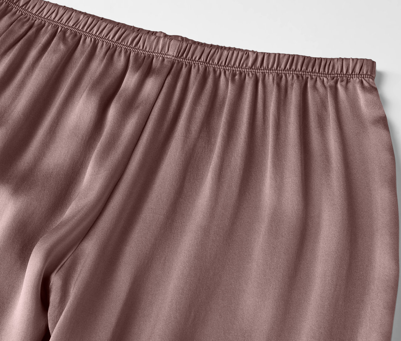 Detailaufnahme einer lila-farbenen Satinschlafanzughose mit Gummibund.