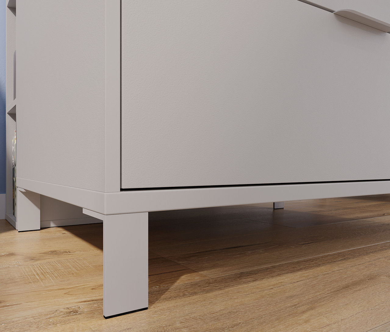 Detailaufnahme einer grauen Kommode aus dem Set »Alkmaar« (Kinderbett, Kommode, Schrank und Wickelaufsatz) auf einem Holzboden.
