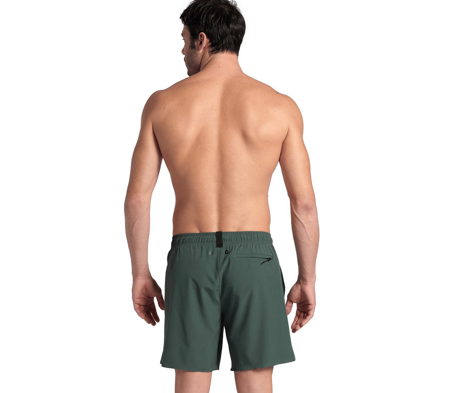 Mann von hinten, oberkörperfrei, trägt grüne arena Evo Badeshorts.