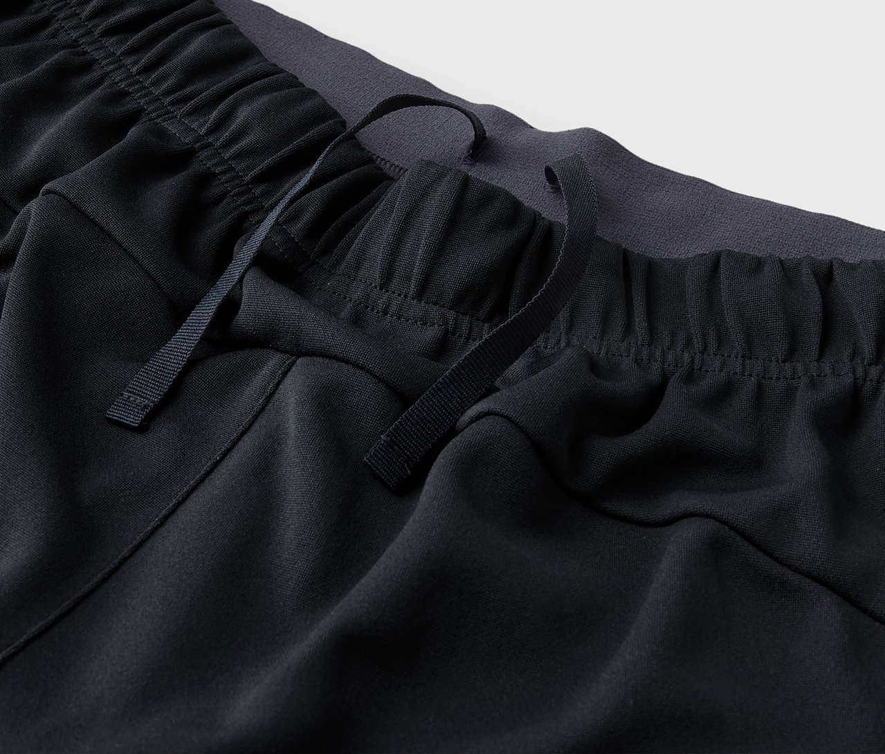 Detailaufnahme einer schwarzen Trainingshose mit Kordelzug.