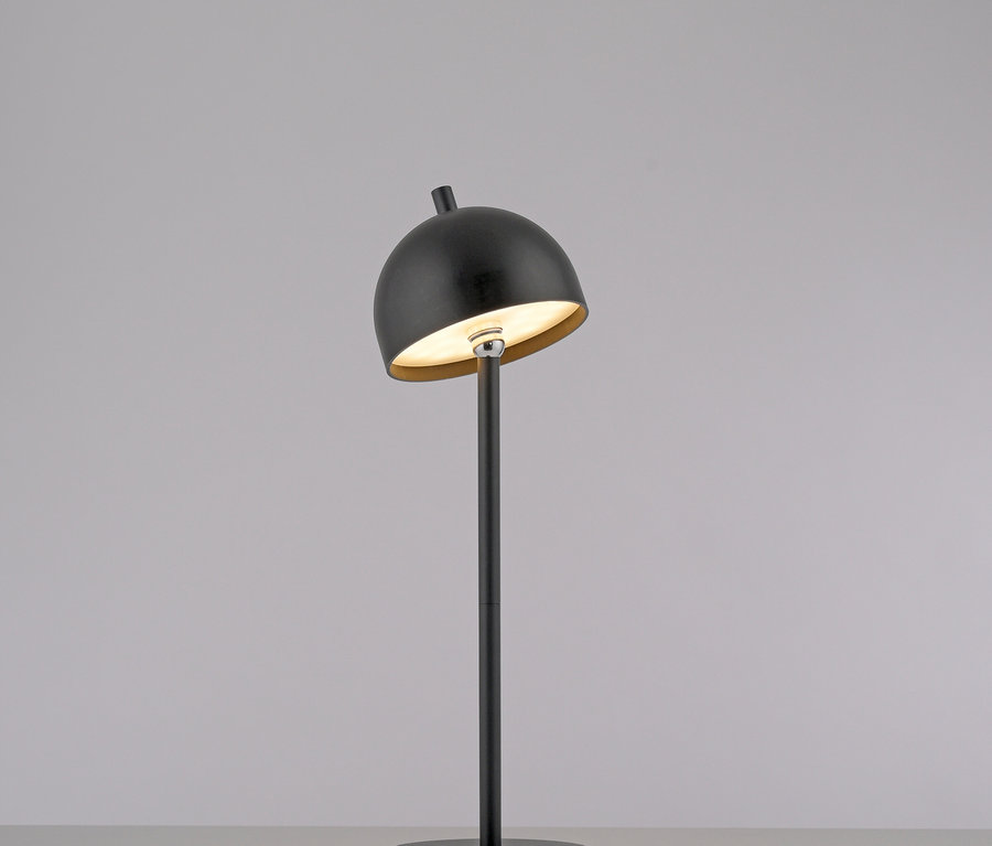 Eine schwarze Lampe steht auf einem Tisch.