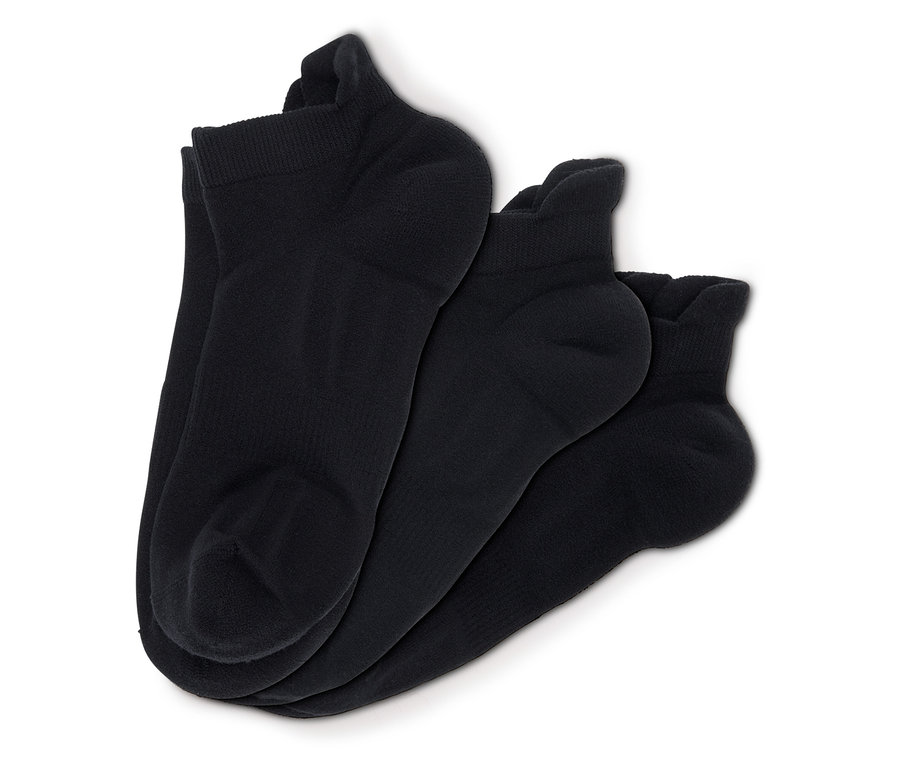 Drei Paar schwarze Socken auf weißem Hintergrund.